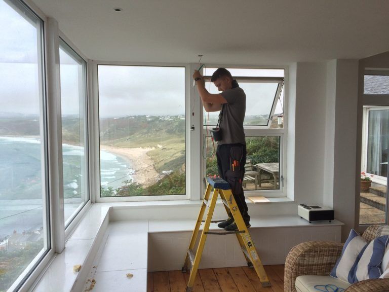 Engineer testing lighting in a room with sea views