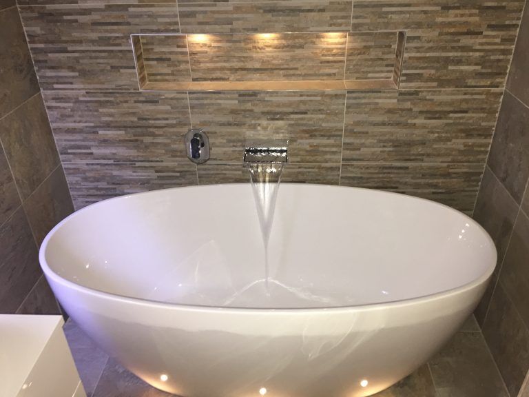 Freestanding bath with a wall-mounted spout
